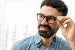 © Maria Vitkovska - Handsome bearded man trying new eyeglasses in optical store