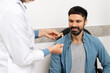 © Maria Vitkovska - Doctor showing hearing aid to patient in medical office