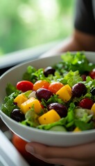 Wall Mural - Vibrant Summer Salad Greens, Mango, Olives, and Tomatoes in a Bowl, Healthy Eating Concept