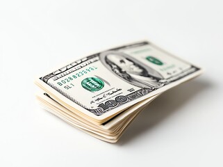 Stack of US dollar bills resting on a smooth surface. The focus on the first bill highlights currency details, white background enhances contrast.