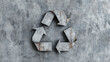 © Wonderful Studio - Recycle conservation renewal sustainability concept. Recycling symbol on a textured grey surface representing sustainability and eco-friendliness.
