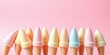 © sasiprapa - Pastel Ice Cream Cones Arranged in a Row Against a Pink Background