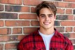© Sanchai - A confident young guy in casual wear leaning against a brick wall, with a charming smile and vibrant urban background