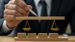 © TA Design - A person in a suit adjusts a wooden scale, symbolizing justice, balance, and fairness in legal matters.