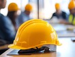 © Ytnart - A close-up view of a yellow hard hat placed on a table during a construction meeting