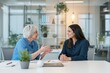 © Pixels Hunter - Senior woman and young woman discussing work in modern office setting.