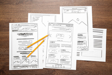 Wall Mural - developing ui design. sketches of website wireframes and pencils on wooden table, top view