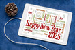 © MarekPhotoDesign.com - Happy New Year 2025 greetings card  - word cloud on a digital tablet with a decorative frosty pine cone