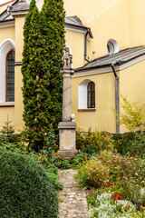 Wall Mural - A stone pillar with a head on top of it is in front of a yellow building