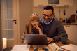 © Drazen - Happy little girl using laptop with her father while he is working at home.