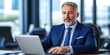 © vstudio - Confident old smart mature businessman working on laptop in modern office successful entrepreneur at desk