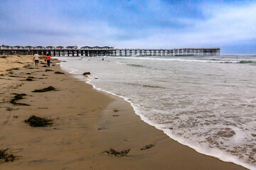 Wall Mural - A pier is visible in the distance, with a beach in the foreground