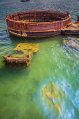 Wall Mural - A large, rusted boat sits in the middle of a body of water