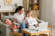 © Pixel-Shot - Female speech therapist working with laptop and little girl in office