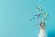 © anak - Colorful pills and capsules spilling from a white bottle on a blue background.