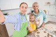 © Pixel-Shot - Happy family taking selfie while preparing dough in kitchen