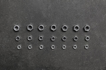 Wall Mural - Arrangement of chrome nuts on grey grunge background