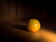 © kong - An orange on a dark yellow background with interesting light and shadow changes,Still life photography.