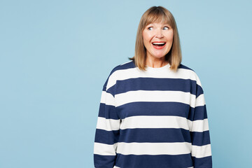 Poster - Elderly shocked surprised happy fun blonde woman 50s years old wear striped sweatshirt casual clothes look aside on area isolated on plain pastel light blue cyan background studio. Lifestyle concept