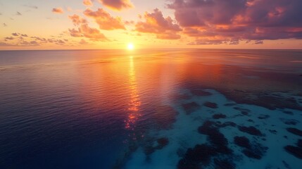 Fototapete - Aerial shot of a serene lagoon glowing softly under the first light of dawn, with vibrant coral reefs beneath, in 4K resolution