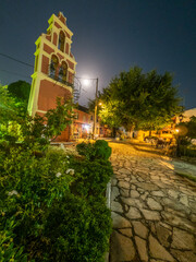 Wall Mural - Night scene in a charming village square, illuminated by moonlight and lamplight.