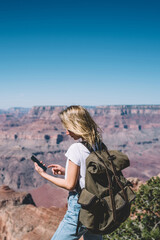 Wall Mural - young hipster girl checking mail on smartphone hiking in mountains on active weekend,female tourist 