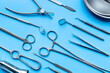 © 9dreamstudio - Surgery equipment and metal tools on blue background, top view. Medical instruments