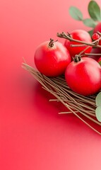 Red pomegranates in a nest on red background.