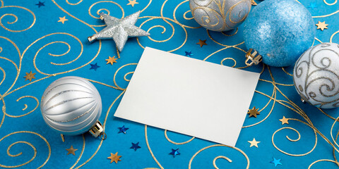 Wall Mural - A festive Christmas card with holiday decorations, including silver and gold baubles, snowflakes, and stars, featuring a blue and silver design with a tree and winter elements2