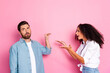 © deagreez - Young couple arguing with expressive gestures against a vibrant pink backdrop in casual wear
