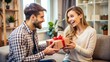 © engincan - Handsome young man is giving gift box to surprised girlfriend at home