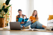 © deagreez - Two young people studying together at home on a casual weekend afternoon