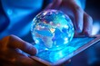 © MdArshed - Close up of human hands using tablet pc with glowing planet earth hologram
