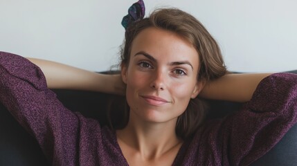 Wall Mural - A 33-year-old White woman poses with her arms behind her head, showcasing a calm and content expression in a cozy setting