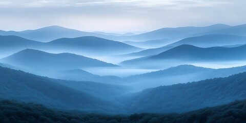 a misty blue mountain range under a pale morning light.