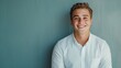 © SunPunjiStudio - Smiling Young Man in White Shirt Against Soft Green Wall Background