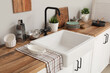 © Pixel-Shot - Sink on wooden counter near white wall in kitchen. Closeup