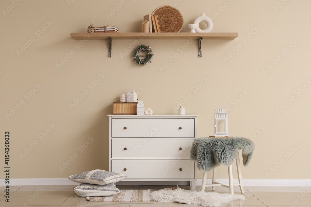 Interior of living room with commode, shelf and Christmas wreath