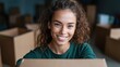 © Dulemegapixel - A joyful woman with curly hair and casual attire holds a large cardboard box, creating feelings of excitement and anticipation, perhaps unpacking or moving.