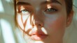 © Kharkovich - Close-up of a young woman face with natural light and shadow patterns