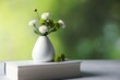 © New Africa - Book and vase with beautiful flowers on grey textured table against blurred green background, closeup