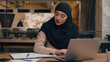 © Yuliia - Muslim woman in hijab female worker freelancer student Arabian businesswoman employee office manager agent online laptop remote work at workplace using computer pc smiling islamic girl business lady