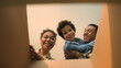 © Yuliia - POV point of view open cardboard box looking inside African American happy family joyful parents son kid little boy child unpacking parcel delivery online shop receive package unboxing moving day home
