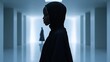© tahu - Silhouetted woman in hijab in modern hallway.
