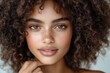 © Milos - This close-up captures the radiant beauty of a young model with curly hair, showcasing her charm and facial features against a softly blurred background.