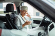 © Davor - Smiling senior professional businesswoman using smartphone in car