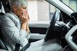 © Davor - Senior professional businesswoman blowing nose on tissue in car