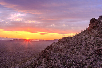 Wall Mural - a sunset over a desert landscape with a mountain in the background