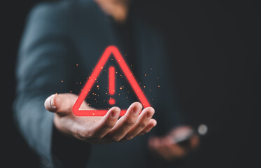 Poster - Businessman holding glowing red triangle caution warning exclamation sign for notification error and maintenance concept.