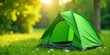 © yut - A vibrant green camping tent sits invitingly in a sun-dappled meadow, ready for a peaceful outdoor adventure in nature.